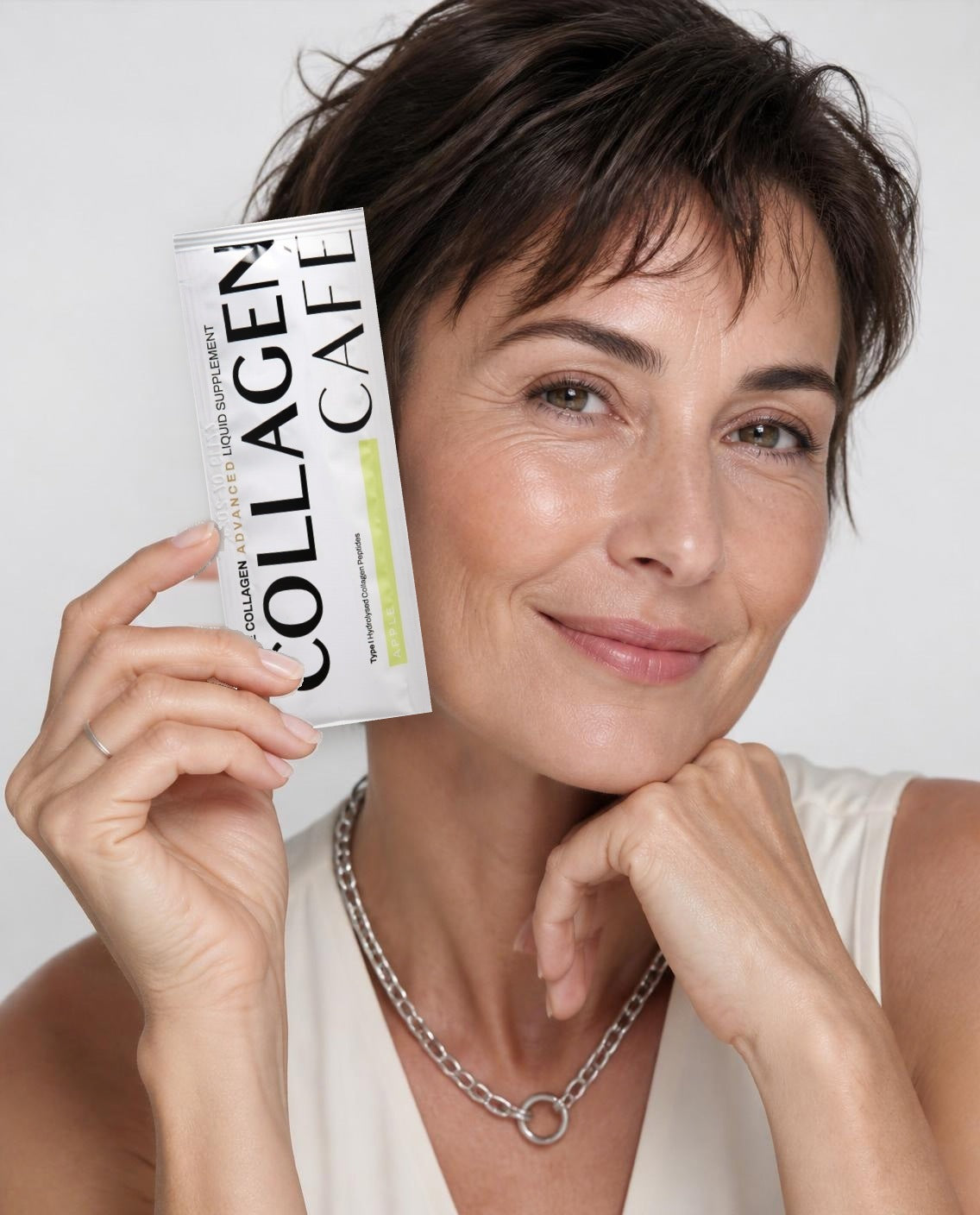 Woman holding a Collagen Café Marine Collagen sachet